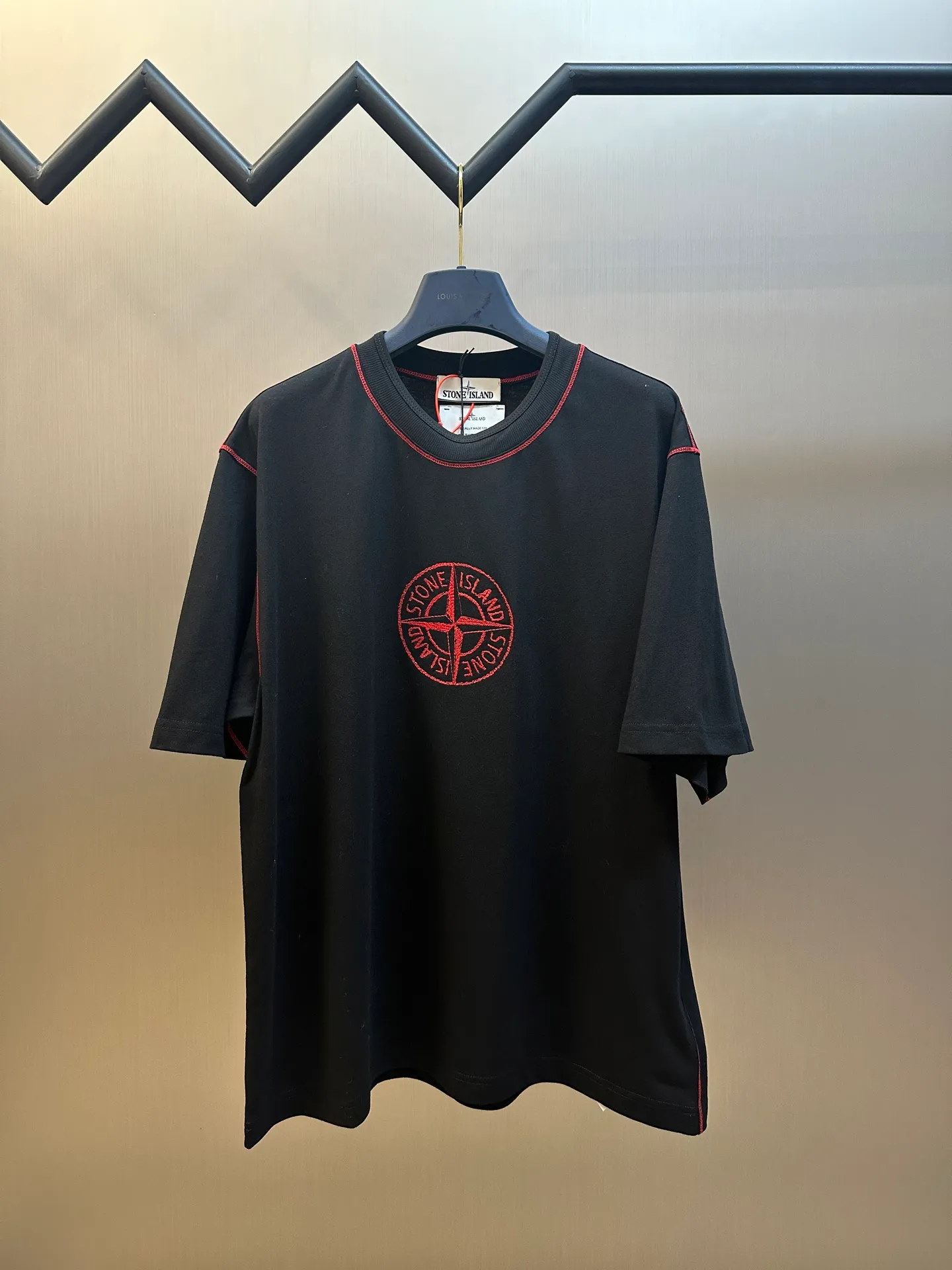 🅿️270 Stonelsland Badge Embroidered Short Sleeves Customized elegant black silk cotton and linen plain fabric, with iconic red Compass badge embroidery on the chest, stitching art, and the beauty of contrasting colors. The red stitches jump on the black base. The collision of fashion and creativity exudes irresistible charm. Imported machine embroidery technology is used, and advanced computer control systems and precision mechanical components are used to realize the red Compass badge embroidery operation. Special machine for reverse topstitching and fine sewing process. Special machine is used for topstitch sewing. It requires careful preparation of the reverse side of the garment before sewing to ensure that the sewing lines are straight, the stitches are even, and the edges are smooth and beautiful.  size：s m l xl